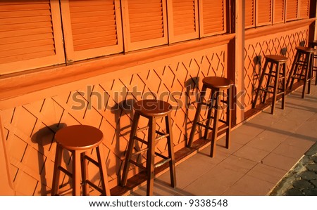 Bar stools of a closed poolside bar in the daytime