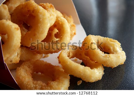 Fried onion rings fast food snack spilling from container