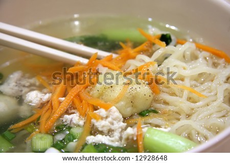 Traditional chinese nodles with soup in bowl with chopsticks