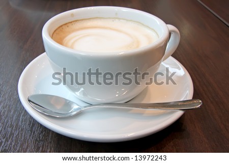 Coffee with foam swirl in round white mug