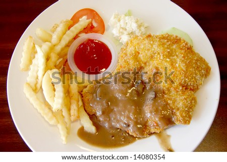 Breaded fried chicken chop with french fries and gravy