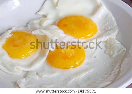 fried eggs whole sunny side up on white plate