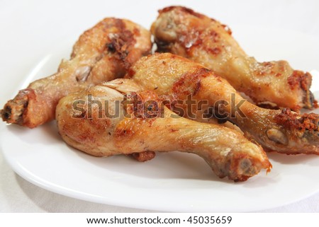 Fried chicken drumstick meat parts on white plate
