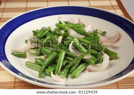 Food photo of fried French bean with sliced onion on plate