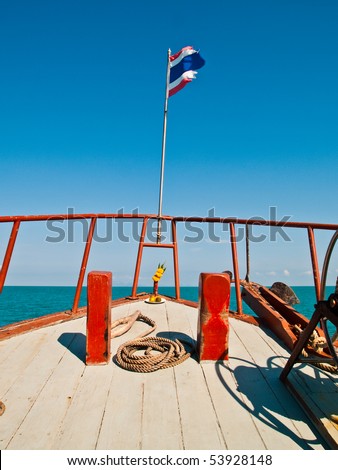 The Front Part of a Thai Boat head to the sea with Thai Flag and Spirit Offerings