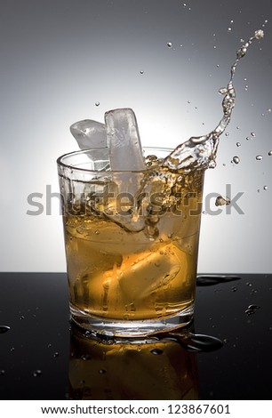 Ice splashes into drink.