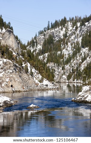The Pend Oreille River in eastern Washington flows through snow covered hills.