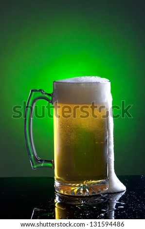 Foam runs down the side of a large mug of beer.