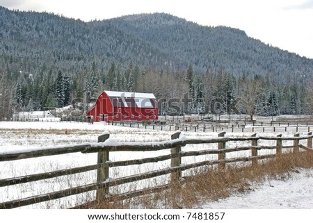 A red barn and a fence make for a peaceful winter setting.