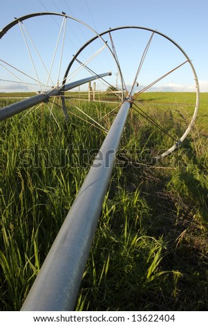 An irrigation pipe leads toward the attached wheel.