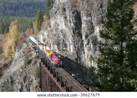 A small tour train travels through the mountains on a scenic journey.