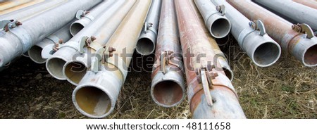 A panoramic image of irrigation pipes laying on the ground.