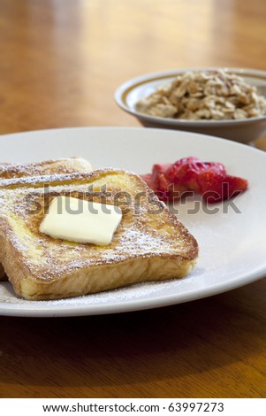 A plate of french toast with a side bowl of oatmeal.