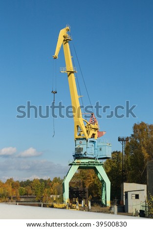 Yellow lifting crane over clear blue sky