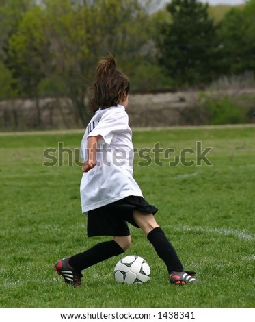 Female soccer player setting up soccer ball