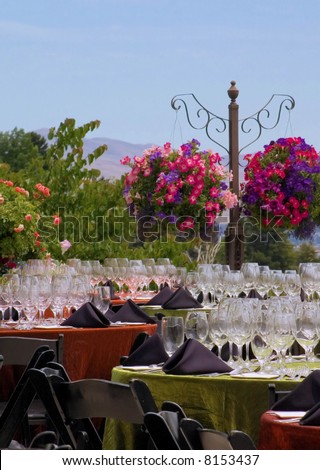 tables set for formal dinner party on outdoor floral decorated patio