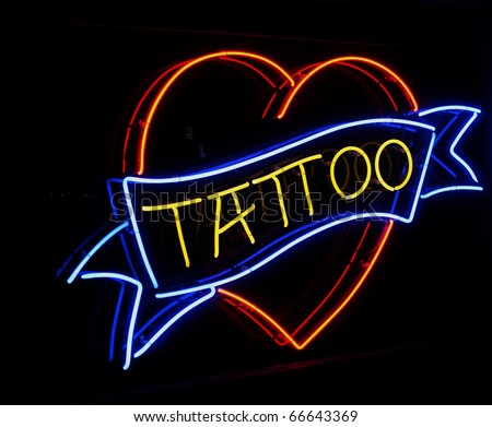 stock photo Heart shaped neon sign with blue TATTOO banner running