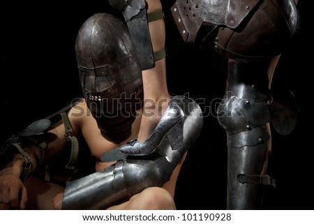 A knight in armour worshiping and holding female leg