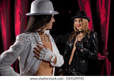 Cabaret performers wearied white and black clothes on stage looking at the audience