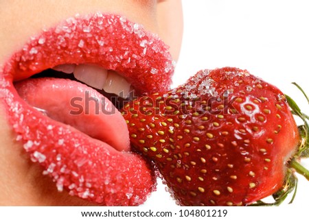 young woman's mouth with red strawberry covered with sugar