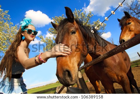 Beautiful girl feeding her horses at ranch