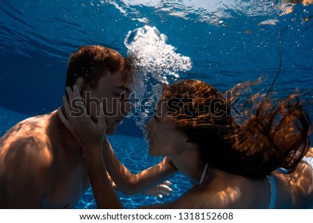 Man and Woman kissing underwater in the swimming pool