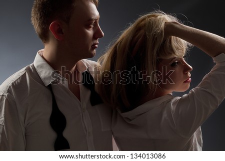Photo of a couple in white shirt and black tie, the man holding sexy woman.
