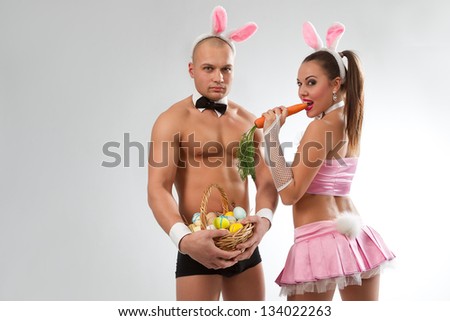 Lovely couple in rabbit costumes with carrots and eggs