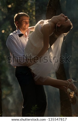 A young beautiful couple dance in a forest