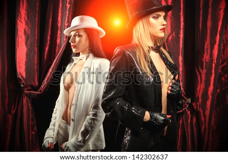 Cabaret performers wared white and black clothes on stage looking at the audience