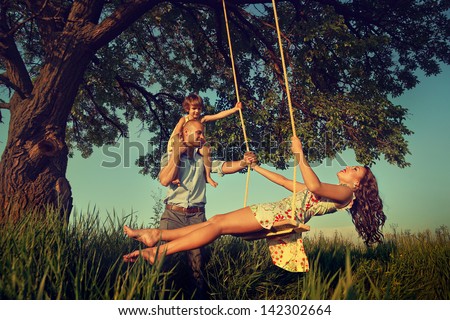 Beautiful Mom On The Swing In The Forest With Her Family