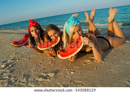 Young stylish ladies at sea with watermelon