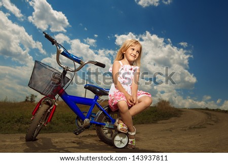 smiling little girl cycling on field