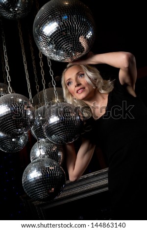 Close-up face of young blonde woman disco mirror ball in hands