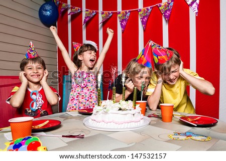 Very emotional little girl rejoice  in her birthday round about her friends