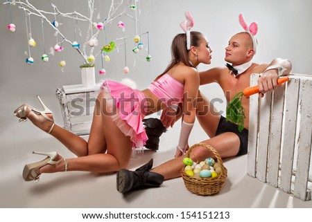 Lovely couple in rabbit costumes with carrots and eggs