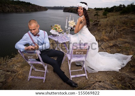 Groom next to table on the rock and excited bride hold fist ok yes gesture with raised arm