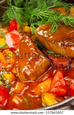 Meat under a red sauce garnished with dill