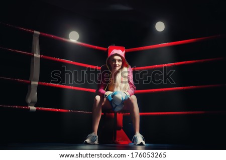 Sports Boxing Woman in box gloves sitting on ring