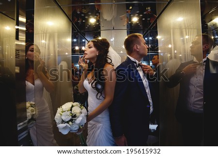 Wedding shot of couple preparing in the lift for going out