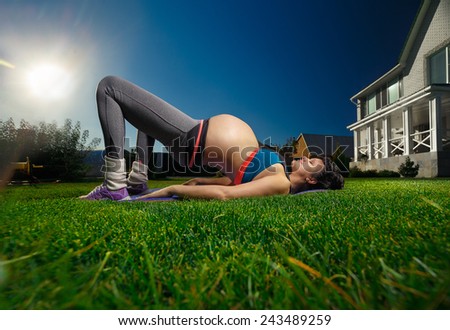 Beautiful pregnant woman doing sport near her house