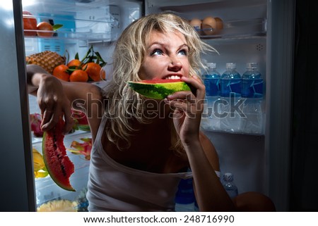 Diet. Beautiful Young Woman near the Refrigerator with healthy food. Fruits in a Fridge
