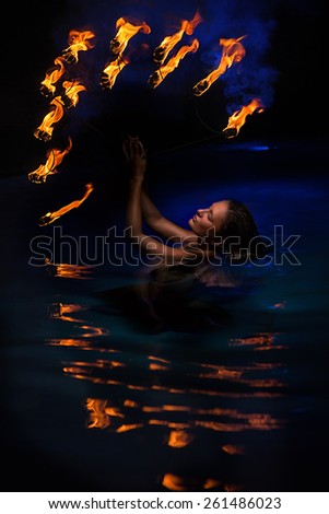 Firedancer woman with fire in water