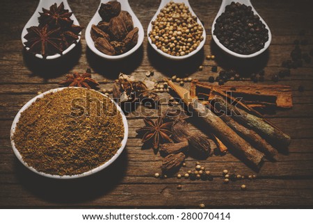 Garam Masala with various seasonings for cooking on white spoons
