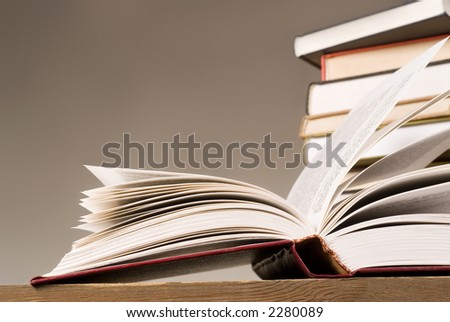 open book and a few books in stock on second plan