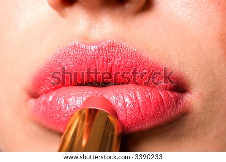 Nice girl making up her face with lipstick