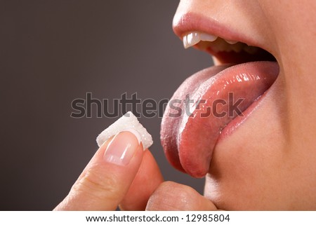 beautiful woman mouth and tongue licking sugar