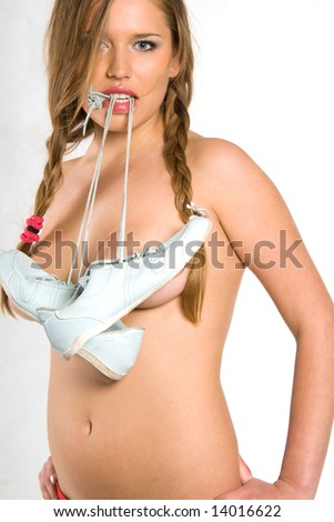stock photo Beautiful naked girl holding sport shoes laces in teeth