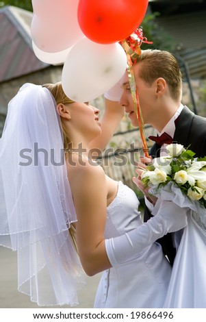 bride and groom with red and white balloons