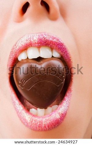 Closeup of woman lips with chocolate candy with lot of copyspace on it